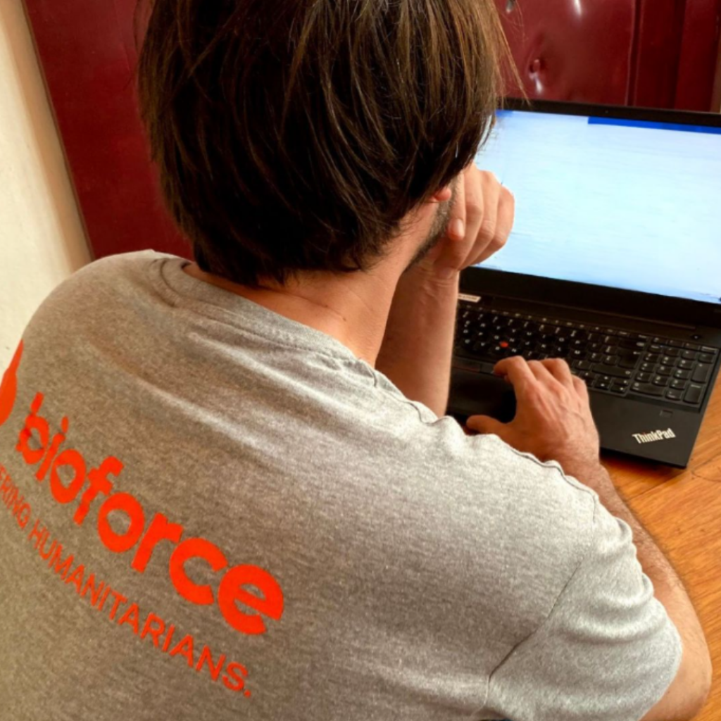 Apprenant de dos, portant le tee-shirt Bioforce, face à un ordinateur.